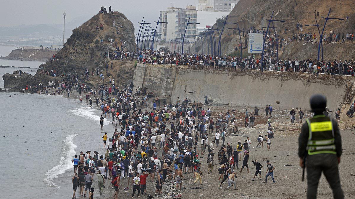 The day 60,000 migrants swept their way into Europe: Wave after wave of incomers storm Spanish city from neighbouring Morocco as protesters throw Nazi salutes