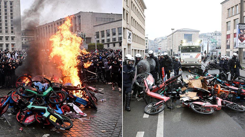 Student riots spread to Belgium as hundreds of hooded protesters clash with police sparking 'total chaos' in Brussels