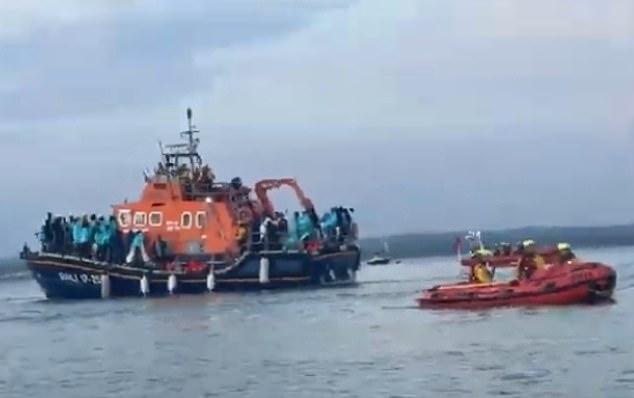 RNLI boats carrying 140 migrants were denied entry to TWO ports before they landed at docks near Portsmouth and were met by hundreds of protesters